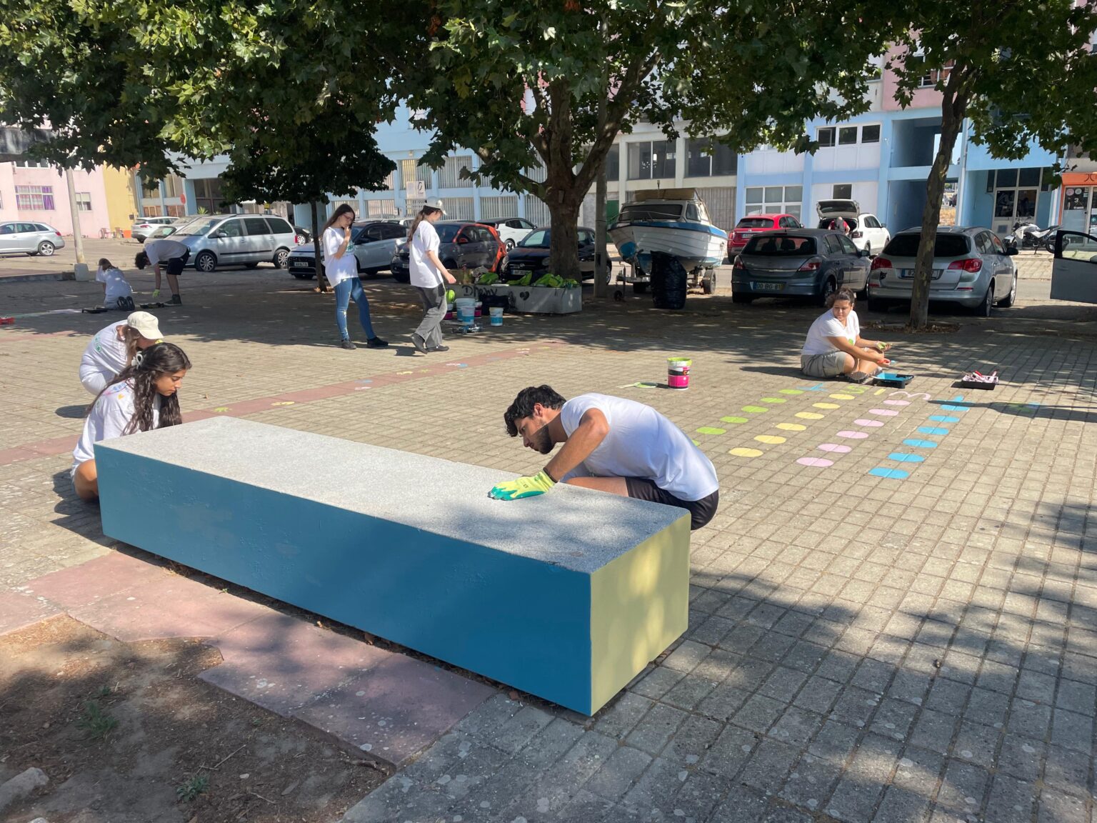 Jovens reabilitam espaço de lazer na Freguesia de São Sebastião. Estão a pintar mobiliário de rua e a desenhar jogos infantis no passeio.